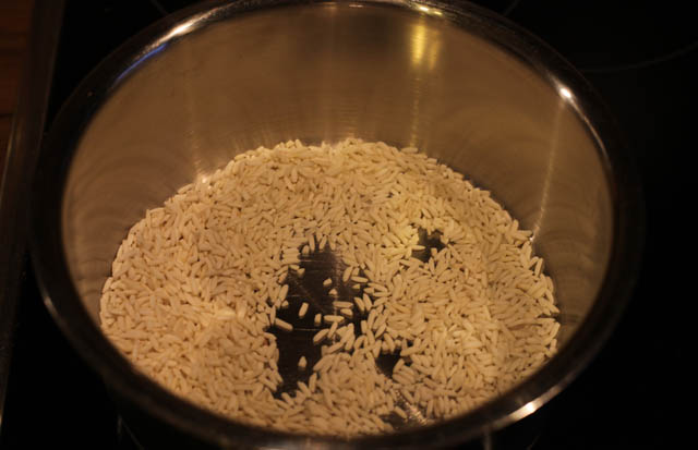 Den Reis in einer Pfanne, Wok oder Topf bei mittlerer bis hoher Hitze anrösten...