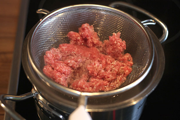 Das Hackfleisch in ein Sieb geben und im kochenden Wasser garen...